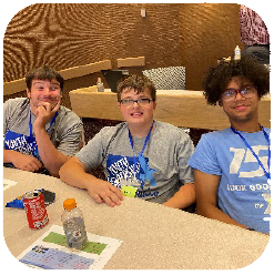 Three young men sitting at table smiling